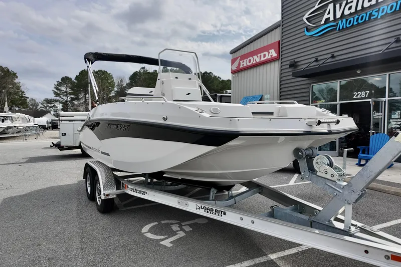 Slide: The Image of 2026 Starcraft SVX 191 OB CC boat on trailer at dealership, featuring sleek design. - 5