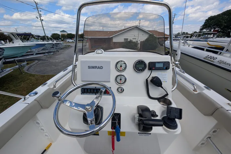 Slide: The Image of 2023 Key West 203 FS boat dashboard with steering wheel and navigation instruments. - 10