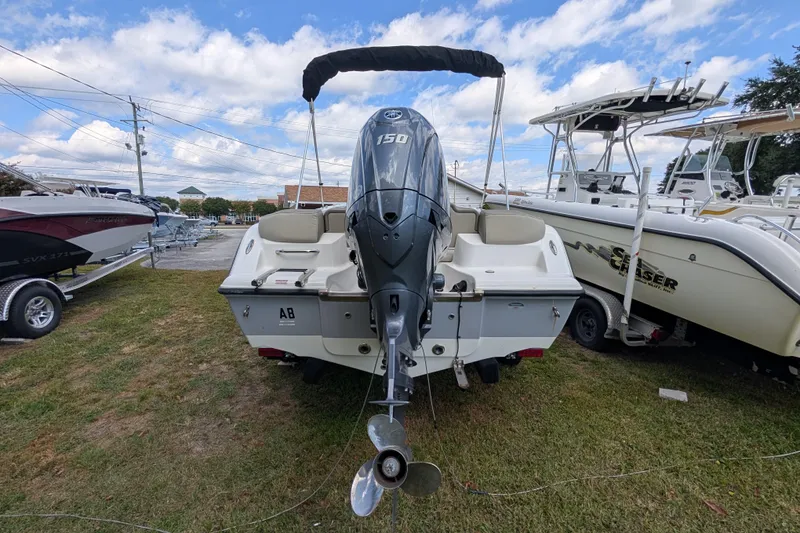 Slide: The Image of 2023 Key West 203 FS boat with 150 HP engine, displayed outdoors on grass. - 3