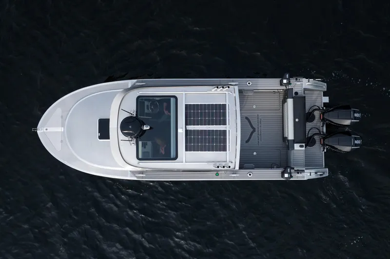 Slide: The Image of 2026 Jasper Marine Defender 22 boat on serene lake with mountainous backdrop. - 17