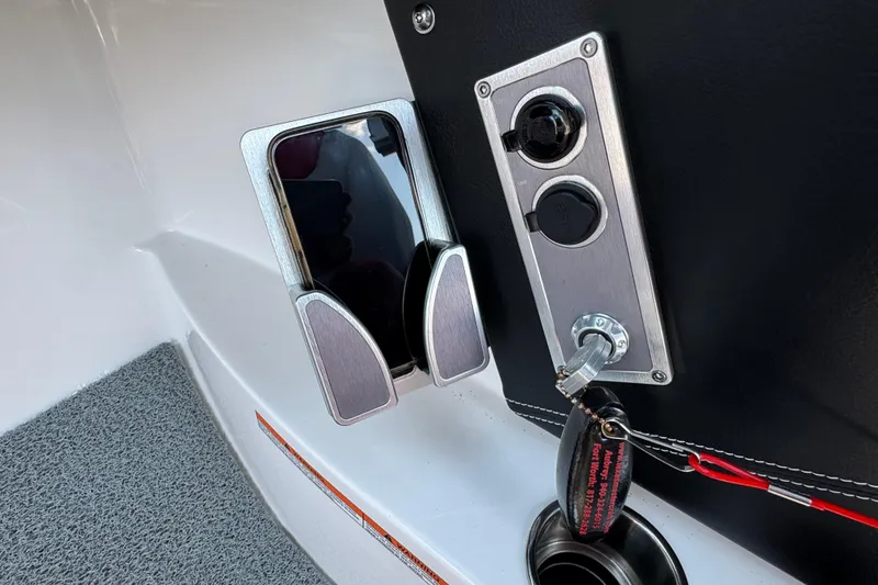 Slide: The Image of 2021 MasterCraft X22 boat dashboard with phone holder and ignition key. - 16