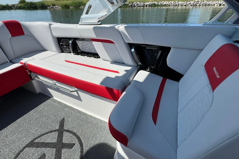 Slide: The Image of 2021 MasterCraft X22 boat interior with red and white seating by the water. - 17