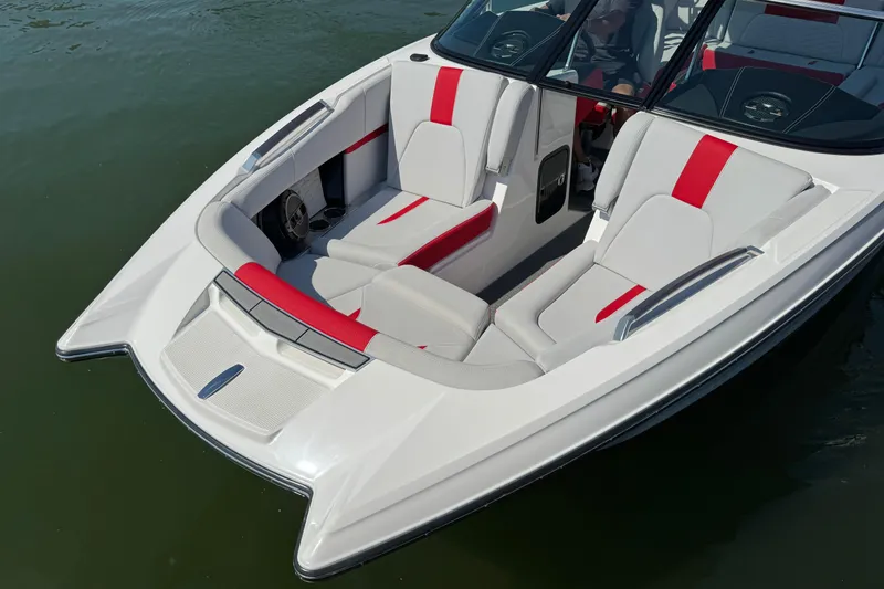 Slide: The Image of 2021 MasterCraft X22 boat interior with red and gray seating on water. - 4