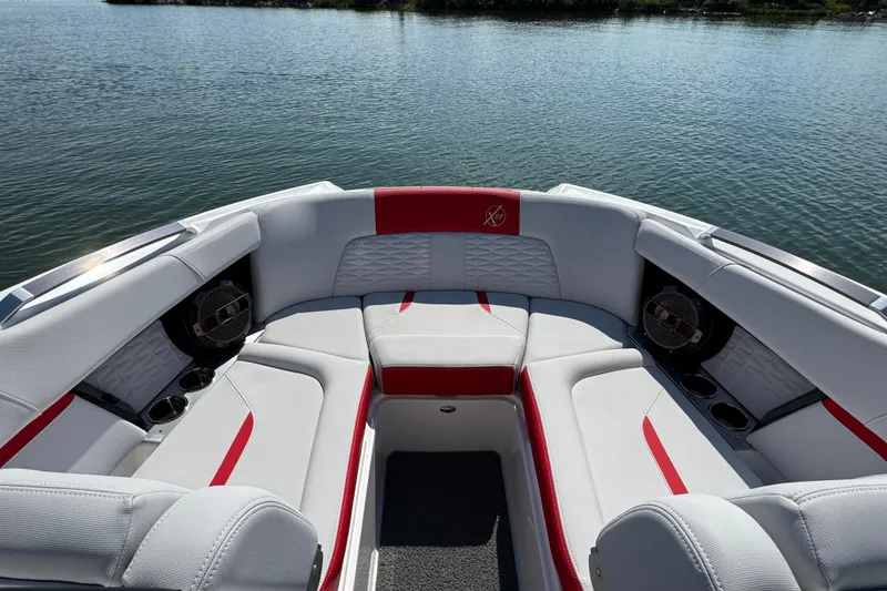 Slide: The Image of 2021 MasterCraft X22 boat interior with red and white seating on calm water. - 8