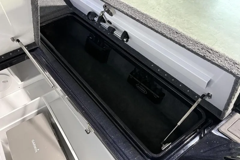 Slide: The Image of Open storage compartment in 2026 Phoenix 721 ZXL boat, featuring hydraulic struts and carpeted interior. - 14