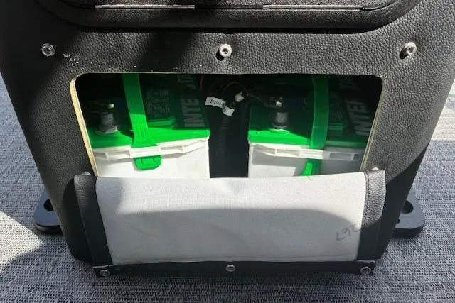 Slide: The Image of 2024 Barletta Cabrio 24CC boat battery compartment with dual green-topped batteries. - 19