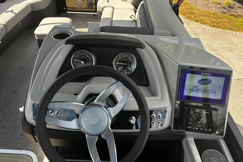 Slide: The Image of 2024 Barletta Cabrio 24CC boat dashboard with steering wheel and digital display. - 22