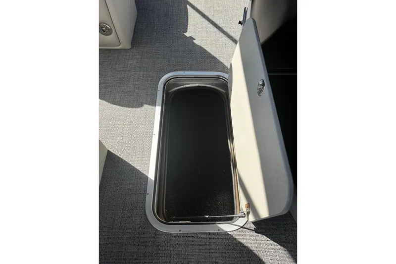 Slide: The Image of 2024 Barletta Cabrio 24CC storage compartment with open hatch on textured flooring. - 27