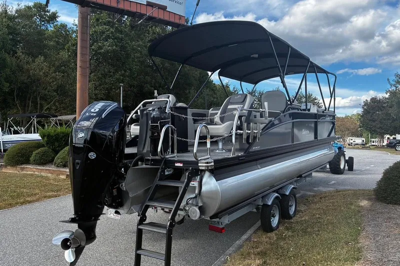 Slide: The Image of 2024 Barletta Cabrio 24CC pontoon boat on trailer, featuring a powerful outboard motor. - 4