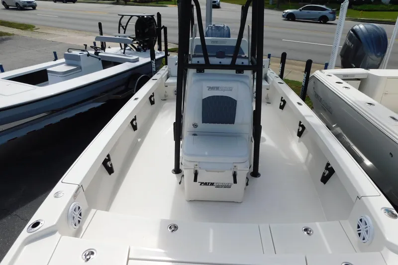 Slide: The Image of 2025 Pathfinder 2500 Hybrid boat interior with seating and storage, parked near a road. - 21