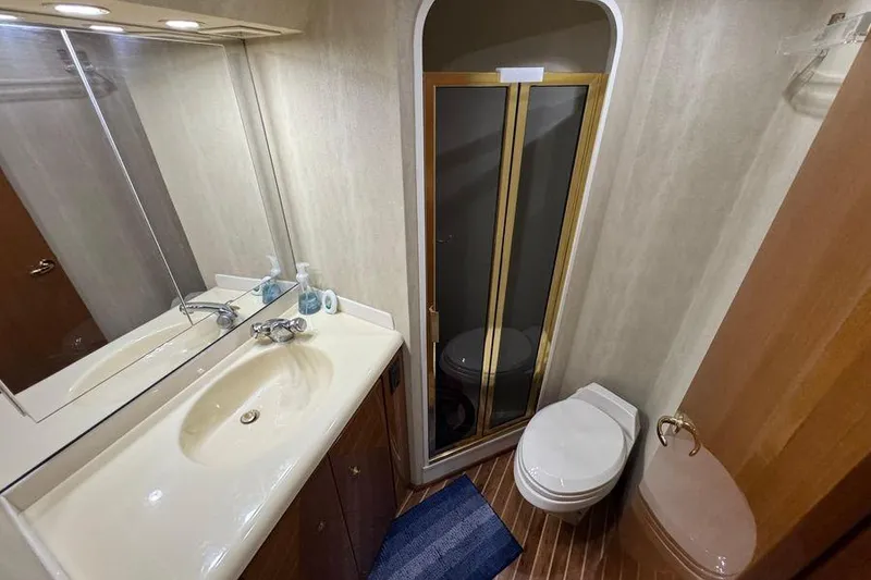 Slide: The Image of Bathroom interior of 2002 Viking 61 Enclosed Bridge yacht, featuring sink, toilet, and shower. - 102