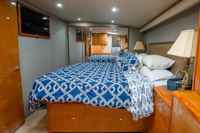 Slide: The Image of Luxurious bedroom interior of 2002 Viking 61 Enclosed Bridge yacht with blue patterned bedding. - 106