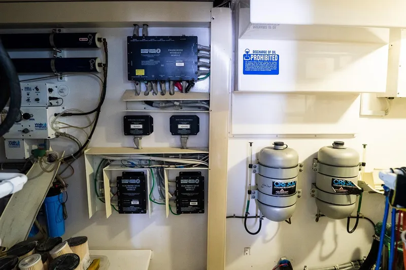 Slide: The Image of Engine room of 2002 Viking 61 Enclosed Bridge with equipment and oil discharge warning. - 116