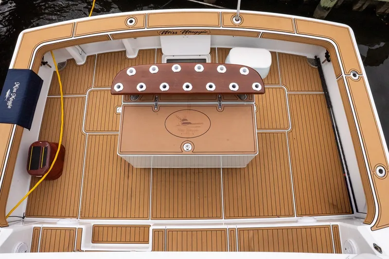 Slide: The Image of 2002 Viking 61 Enclosed Bridge yacht deck with teak flooring and fishing rod holders. - 14