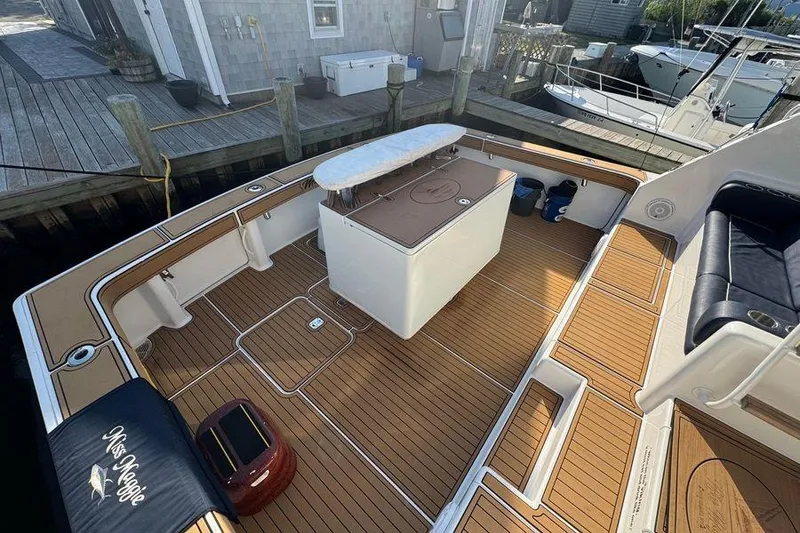 Slide: The Image of 2002 Viking 61 Enclosed Bridge yacht deck with teak flooring and seating area. - 19