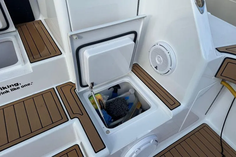 Slide: The Image of Storage compartment on 2002 Viking 61 Enclosed Bridge yacht, featuring cleaning supplies and teak flooring. - 24