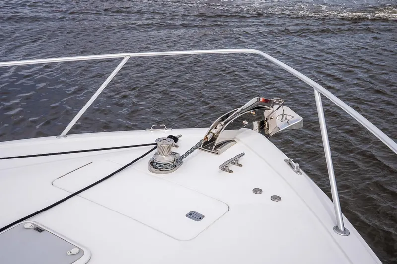 Slide: The Image of Bow of 2002 Viking 61 Enclosed Bridge yacht with anchor and railing on water. - 47