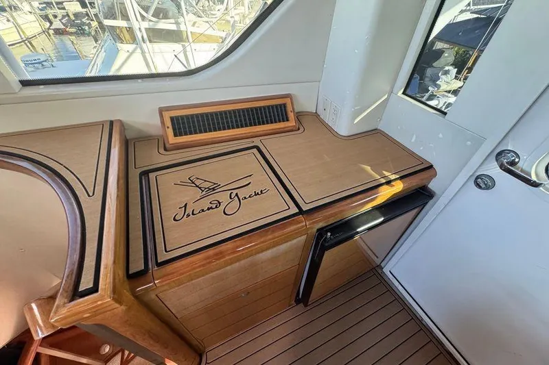 Slide: The Image of Interior of 2002 Viking 61 Enclosed Bridge yacht with wooden cabinetry and "Island Yacht" logo. - 52