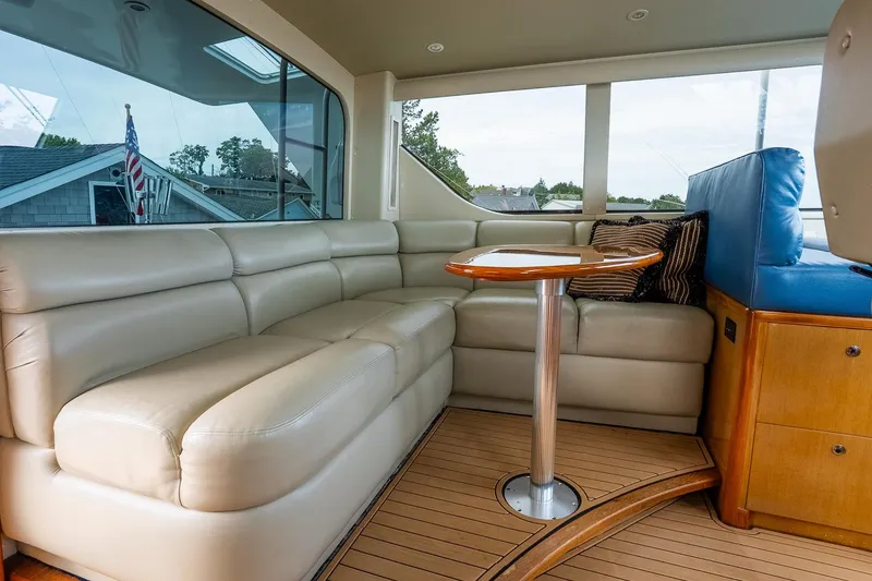 Slide: The Image of Luxurious interior of 2002 Viking 61 Enclosed Bridge yacht with leather seating and wooden table. - 54