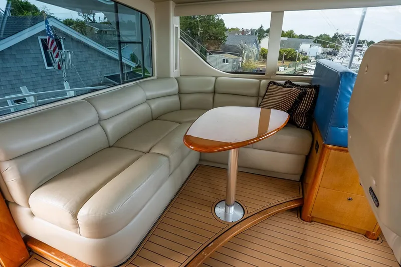 Slide: The Image of Luxurious interior of 2002 Viking 61 Enclosed Bridge yacht with leather seating and wooden table. - 56