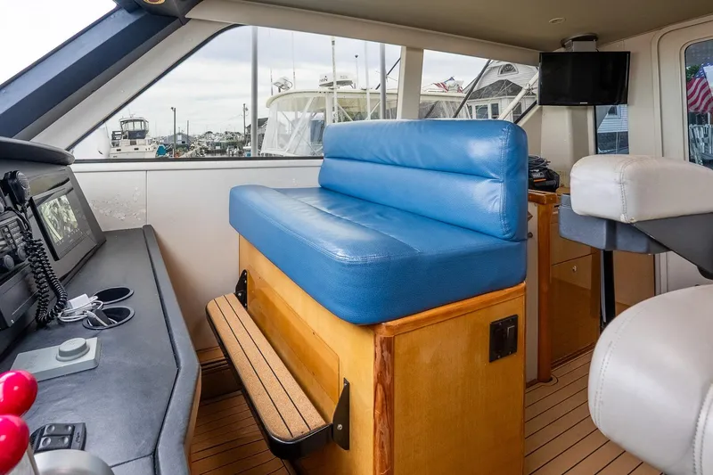 Slide: The Image of Interior of 2002 Viking 61 Enclosed Bridge yacht with blue seating and navigation equipment. - 61