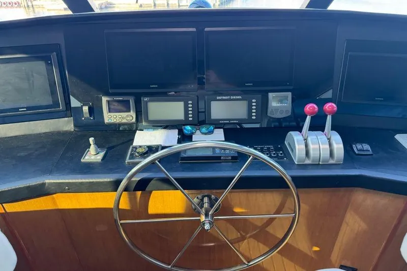 Slide: The Image of Control panel of a 2002 Viking 61 Enclosed Bridge yacht with steering wheel and navigation equipment. - 64