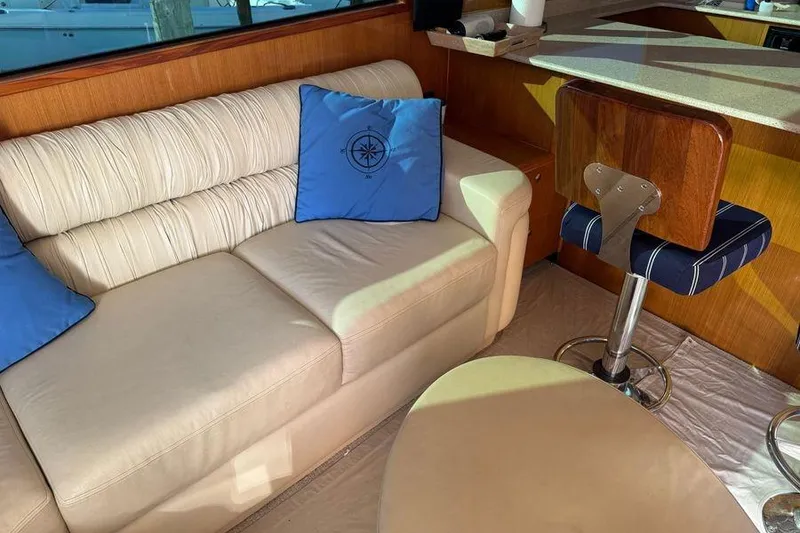 Slide: The Image of Luxurious interior of 2002 Viking 61 Enclosed Bridge with cream sofa and blue cushions. - 78