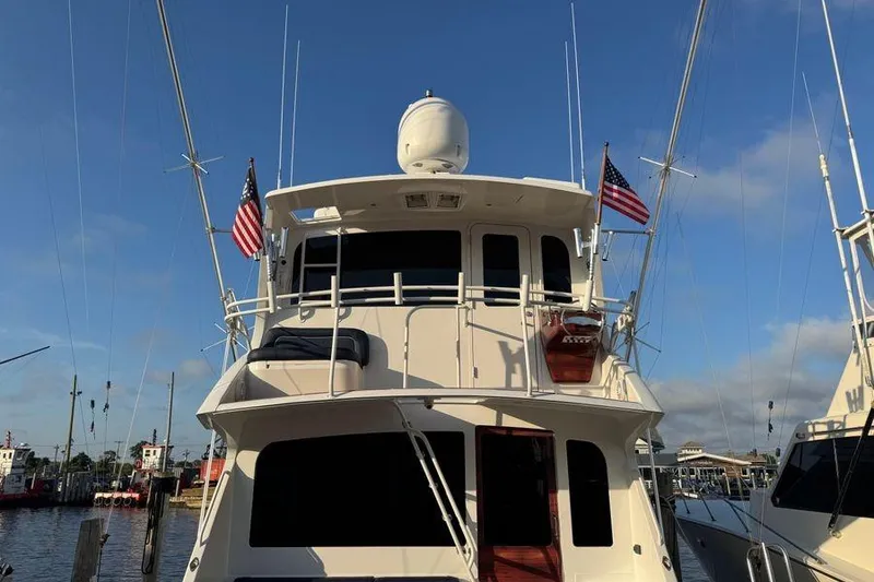Slide: The Image of 2002 Viking 61 Enclosed Bridge yacht docked with American flags. - 8