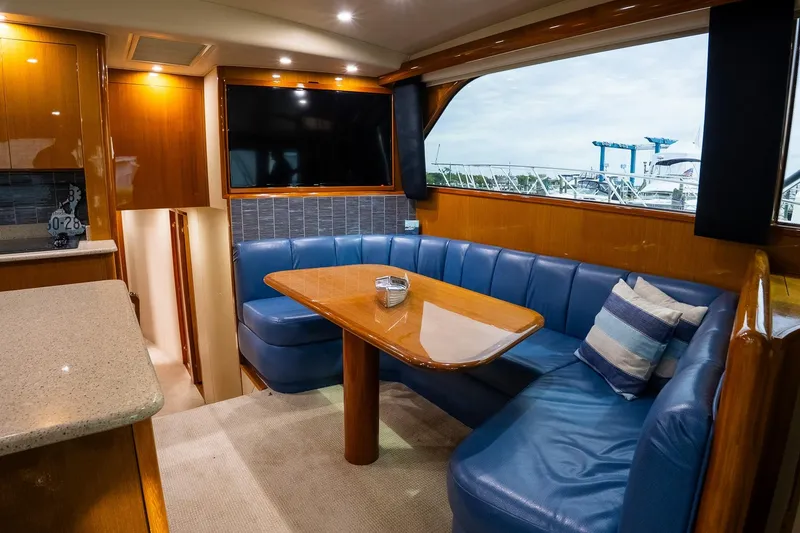 Slide: The Image of Luxurious interior of 2002 Viking 61 Enclosed Bridge yacht with blue seating and large window. - 88