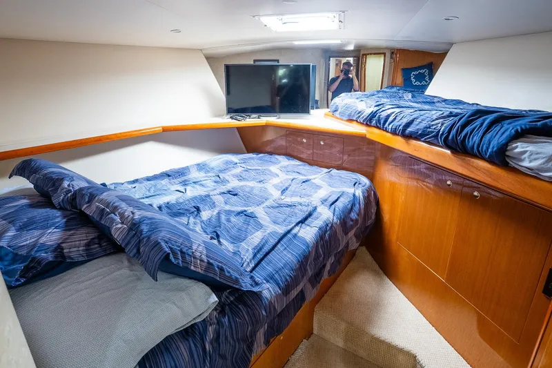 Slide: The Image of Cozy cabin interior of 2002 Viking 61 Enclosed Bridge yacht with blue bedding. - 97