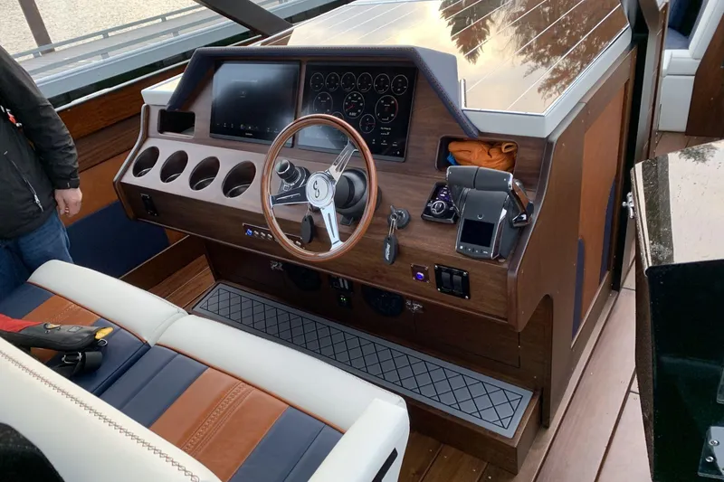 Slide: The Image of 2023 StanCraft 340 Hammerhead Center Console dashboard with wooden finish and modern controls. - 10