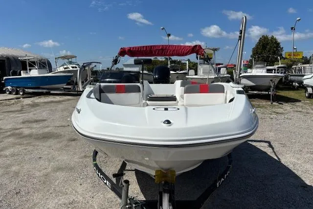 Slide: The Image of 2020 Tahoe T16 boat with red canopy, parked on gravel lot under blue sky. - 59