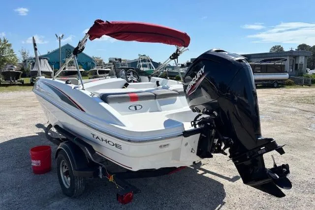 Slide: The Image of 2020 Tahoe T16 boat with Mercury outboard motor, parked on a trailer in a sunny lot. - 61