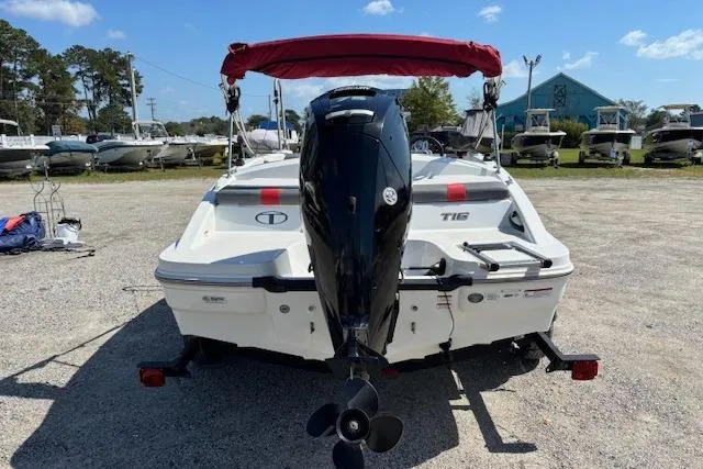 Slide: The Image of 2020 Tahoe T16 boat with red canopy, parked on gravel lot. - 62