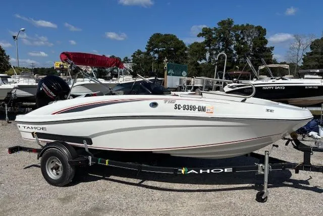 Slide: The Image of 2020 Tahoe T16 boat on trailer, parked in marina with other boats. - 65