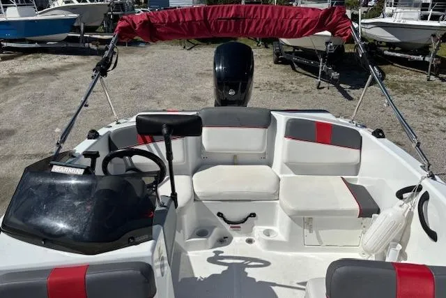 Slide: The Image of 2020 Tahoe T16 boat interior with red accents and steering wheel, parked on gravel. - 81