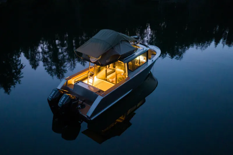 Slide: The Image of Jasper Marine Defender 22 boat, 2026 model, docked by rocky shoreline in serene waters. - 6