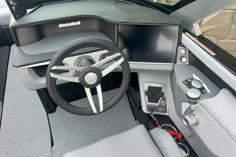 Slide: The Image of 2025 MasterCraft XT24 boat dashboard with steering wheel and control panel. - 2