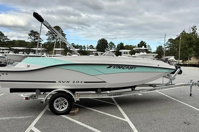 The Image of 2026 Starcraft SVX 191 OB boat on trailer in parking lot, cloudy sky background. - 0