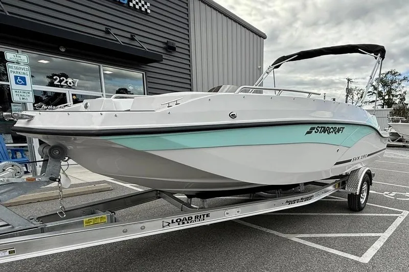 Slide: The Image of 2026 Starcraft SVX 191 OB boat on trailer, parked outside a building. - 3