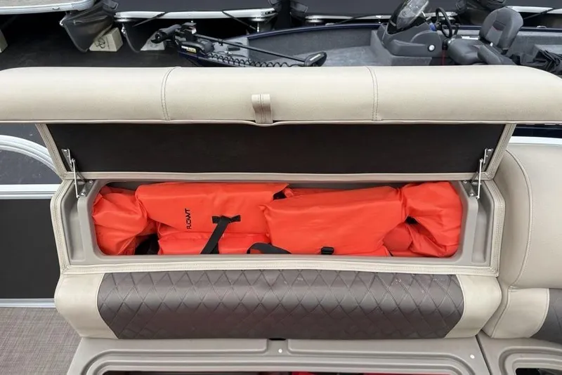 Slide: The Image of 2021 Sun Tracker Party Barge 20 DLX seat storage with orange life jackets. - 10