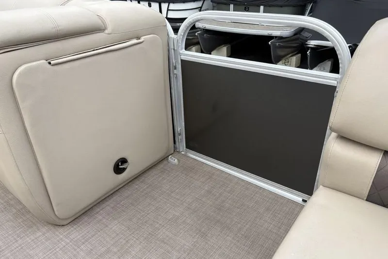 Slide: The Image of 2021 Sun Tracker Party Barge 20 DLX interior with beige seating and storage compartment. - 14