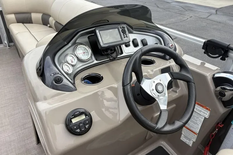 Slide: The Image of 2021 Sun Tracker Party Barge 20 DLX dashboard with steering wheel and gauges. - 18