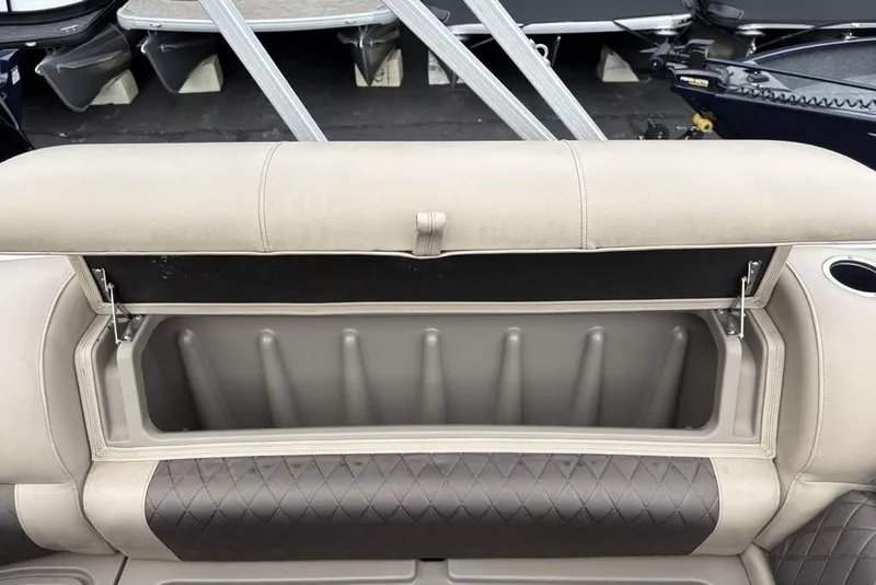 Slide: The Image of 2021 Sun Tracker Party Barge 20 DLX storage compartment with cushioned seating and cup holder. - 26