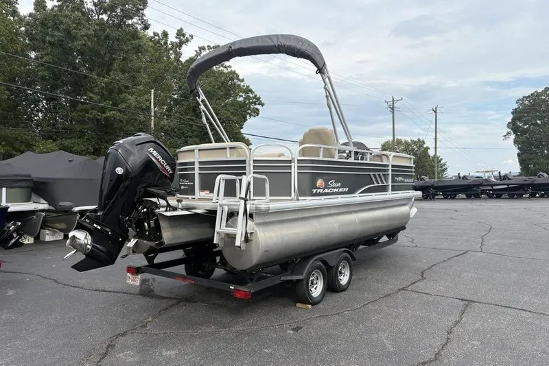 Slide: The Image of 2021 Sun Tracker Party Barge 20 DLX pontoon boat on trailer, parked outdoors. - 4