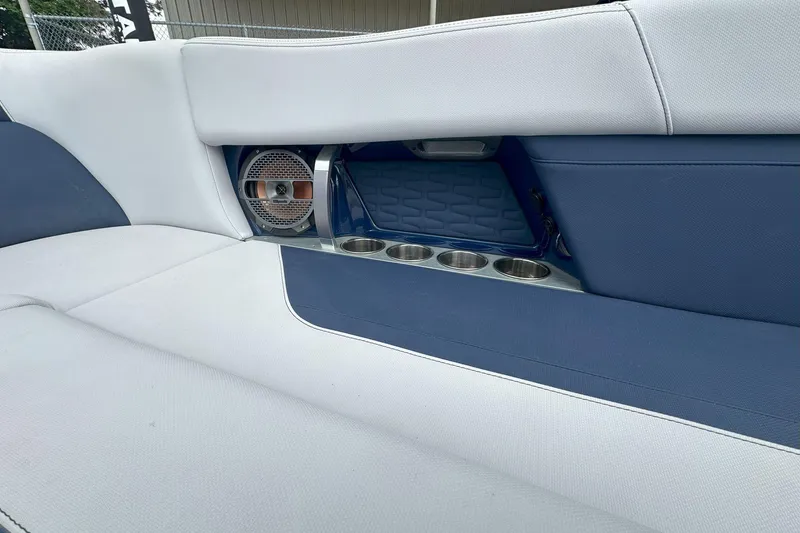 Slide: The Image of 2021 MasterCraft X24 interior with blue and white seating, cup holders, and speaker. - 12