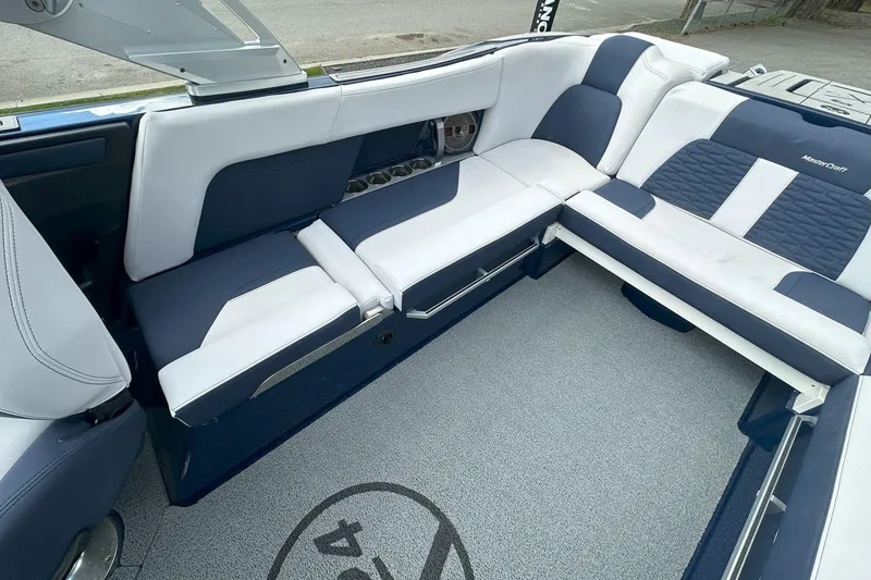 Slide: The Image of 2021 MasterCraft X24 boat interior with blue and white seating, featuring modern design and comfort. - 6