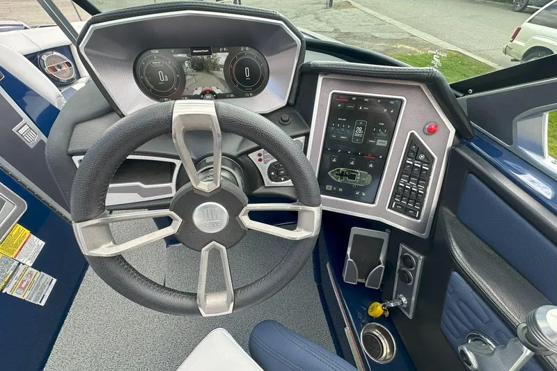 Slide: The Image of 2021 MasterCraft X24 boat dashboard with steering wheel and digital controls. - 7