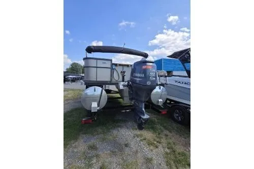 Slide: The Image of 2015 Manitou 20 Oasis Angler pontoon boat with Yamaha outboard motor, parked outdoors. - 6
