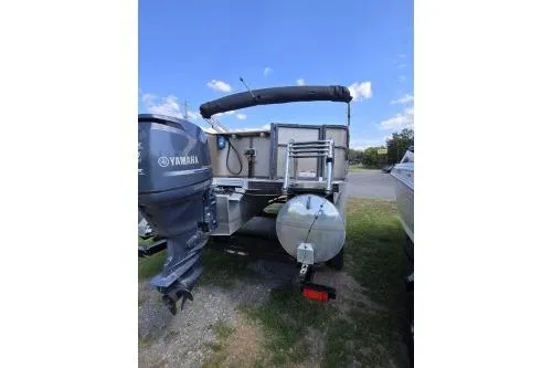 Slide: The Image of 2015 Manitou 20 Oasis Angler pontoon boat with Yamaha outboard motor, parked outdoors. - 7